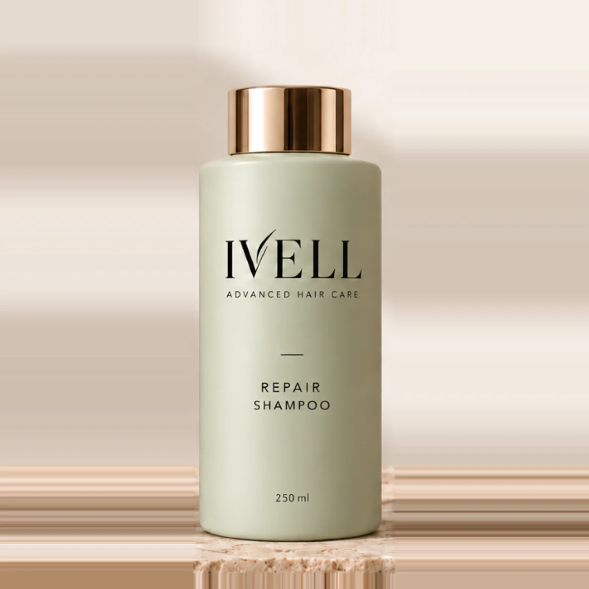 Frasco de 250 ml de IVELL Repair, color verde salvia con tapón dorado, sobre una piedra de travertino.