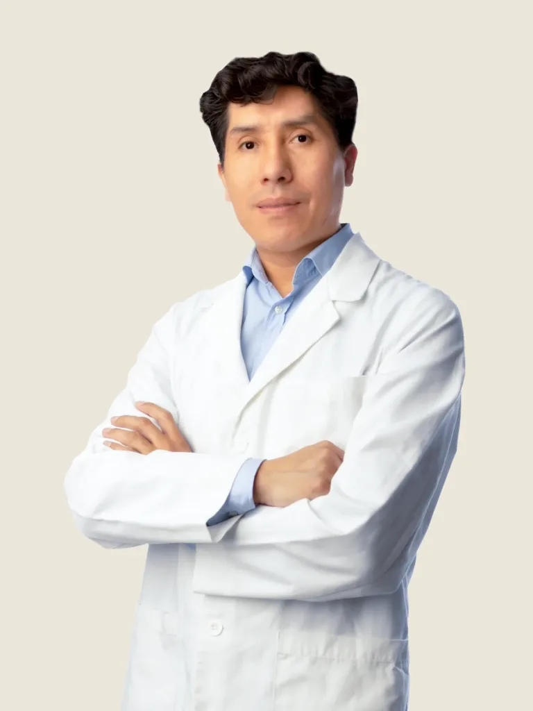 Retrato del Dr. Rubén Arenas, dermatólogo especialista en tricología, con bata blanca y los brazos cruzados.